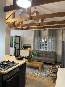 a kitchen and living room with a couch and a stove at The Red door cottage in Pretoria