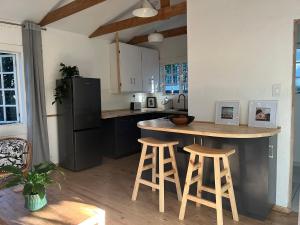 a kitchen with a island with stools and a refrigerator at The Red door cottage in Pretoria +6 photos