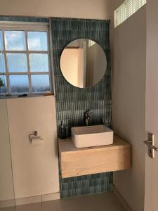 a bathroom with a sink and a mirror at The Red door cottage in Pretoria