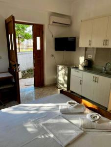 a bedroom with a bed and a kitchen with a tv at VIOLA Seaside Villa in Ksamil