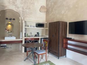 a living room with a table and a television at Castelmar Hotel in Campeche