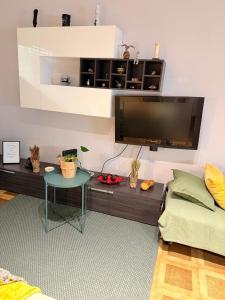 a living room with a table and a flat screen tv at Studio Central na Amadora, Vista da Cidade, Sossegado, a 15min de Lisboa in Amadora