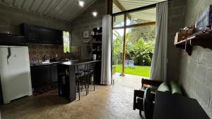 a kitchen with a refrigerator and a counter with a table at Cabana para casal no Vale do Cuiabá Itaipava in Araras Petropolis +22 photos