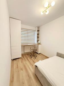 a bedroom with a bed and a desk and a window at Mirajul Modern Apartment - Comfort & Style in Turda