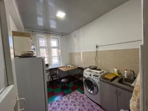 a kitchen with a washing machine in a kitchen at Flat in mountains in Yangiobod