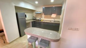 a small kitchen with a table and a refrigerator at RESIDENCE OUARZAZATE in Ouarzazate