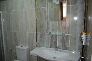 a bathroom with a sink and a toilet and a mirror at Grand Krone Hotel in Çınarcık +28 photos