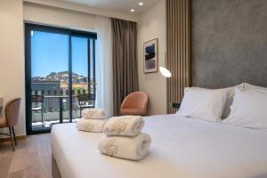 a hotel room with a bed with towels on it at GRAND PATELLI in Myrina +45 photos