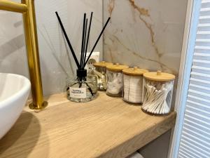 a wooden shelf with five jars on a bathroom counter at Casa Dos in Hendrik-Ido-Ambacht +18 photos