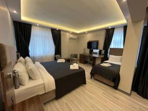 a hotel room with two beds and a desk at Grand Krone Hotel in Çınarcık