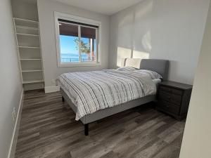 ein Schlafzimmer mit einem Bett und einem Fenster in der Unterkunft Ocean Whispers in Nanaimo