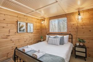 a bedroom with a bed in a log cabin at Dog-Friendly A-Frame with Hot Tub and Firepit in Hedgesville +41 photos