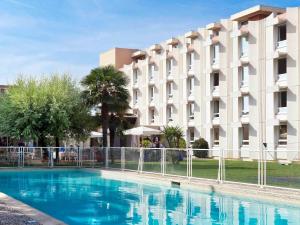 a swimming pool in front of a building at Novotel Nice Aéroport Cap 3000 in Saint-Laurent-du-Var