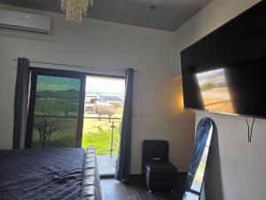 a bedroom with a bed and a window and a chair at Luana's 0601 in Choluteca