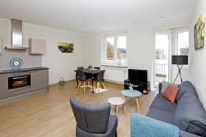 a living room with a couch and a table at Apartment MOSELGARTEN - ÜberSchwang in Piesport