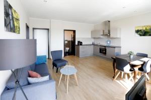 a living room with a blue couch and a table at Apartment MOSELGARTEN - ÜberSchwang in Piesport