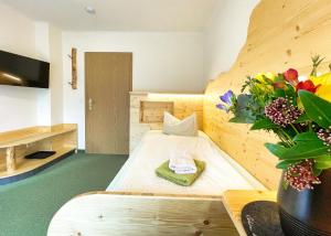 a room with a bed and a vase of flowers at Pension Zum Talwächter im Sandsteinidyll in Rathen