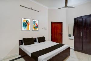 a bedroom with a large bed and a brown cabinet at Hotel O Hotel Brijwasi in Lucknow