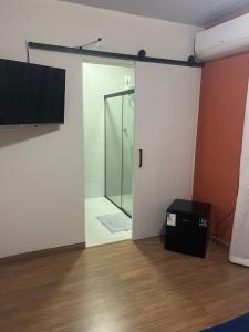 a glass door leading to a shower in a room at Pousada Sete Colinas in Bragança Paulista