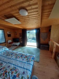 a bedroom with a bed and a large window at Vceli RAJ Bojnice in Bojnice