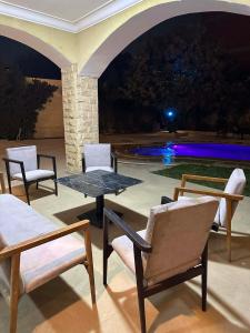 a patio with chairs and a table and a pool at Selora Villa in Cairo