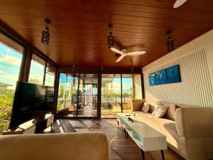 a living room with a couch and a flat screen tv at Seaside Drift in Huraa