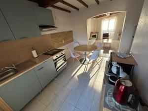 a kitchen with a table and a dining room at Le PATIO Beau Duplex terrasse 2 chambres 5mn théâtre antique in Orange +7 photos