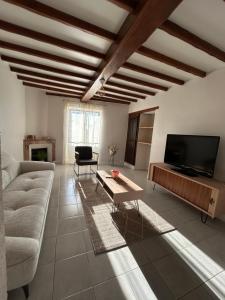 a living room with a couch and a tv at Le PATIO Beau Duplex terrasse 2 chambres 5mn théâtre antique in Orange
