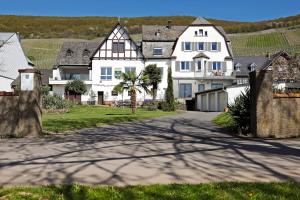 a large white house with a palm tree on a street at Apartment MOSELGARTEN - Domherren-Suite in Piesport +15 photos
