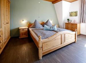 a bedroom with a large wooden bed with blue pillows at Apartment MOSELGARTEN - Domherren-Suite in Piesport