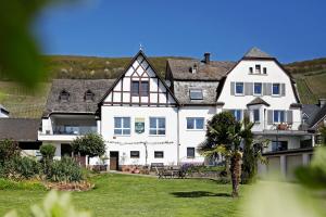 a large white house with a palm tree in the yard at Apartment MOSELGARTEN - Domherren-Suite in Piesport