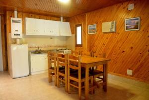 a kitchen with a table and chairs and a refrigerator at Cabañas Las Marias in San Rafael