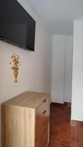 a flat screen tv on a wall with a wooden cabinet at Piedra Marina Bahia in Bahía de Caráquez