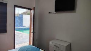 a room with a bedroom with a window and a television at Piedra Marina Bahia in Bahía de Caráquez
