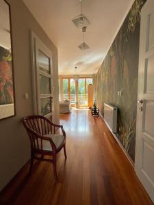 a hallway with a chair and a living room at WILLA BOHEMA in Łagów