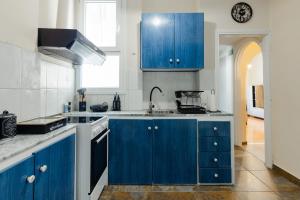 a kitchen with blue cabinets and a sink at Feel's Like Home Apartment in Chios Town in Chios