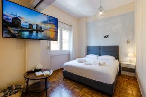 a bedroom with a large bed and a tv on the wall at Feel's Like Home Apartment in Chios Town in Chios