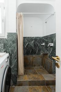 a bathroom with a shower and a washer and dryer at Feel's Like Home Apartment in Chios Town in Chios +18 photos