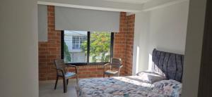 a bedroom with a bed and a brick wall at Don Pedro in Buga