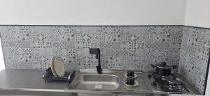 a kitchen counter with a sink and a stove at Don Pedro in Buga