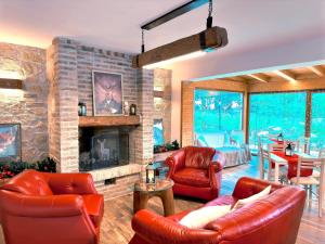 a living room with leather furniture and a stone fireplace at La Baita Del Cervo 2 in Castel di Sangro