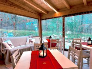 a room with tables and chairs and a large window at La Baita Del Cervo 2 in Castel di Sangro
