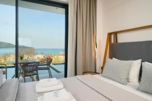 a bedroom with a bed and a view of the ocean at Videre Golden Private Pool Suites in Potamiá +163 photos