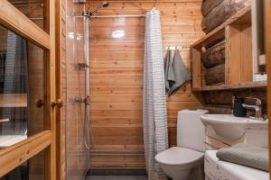 a wooden bathroom with a shower and a toilet at Pikkukelo Ruka in Ruka +51 photos