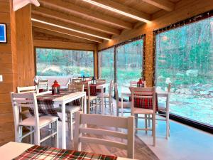 a restaurant with white tables and chairs and windows at La Baita Del Cervo 2 in Castel di Sangro