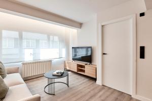 a living room with a couch and a tv and a table at AHH ATLANTIC HORIZON HOMES fa in A Coruña