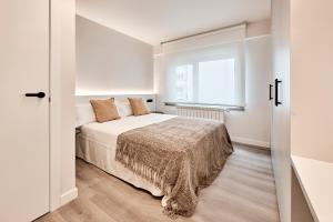a white bedroom with a bed and a window at AHH ATLANTIC HORIZON HOMES fa in A Coruña