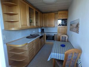 a kitchen with wooden cabinets and a sink and a table at Charmante Ferienwohnung Katja in Morbach-Hoxel in Morbach