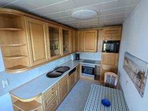 a small kitchen with wooden cabinets and a sink at Charmante Ferienwohnung Katja in Morbach-Hoxel in Morbach
