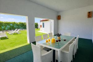 a dining room with a table and chairs with wine glasses at Villa Andy -private yard, swimming pool, panoramic view in Imotski